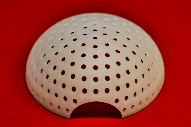 A white, domed chamber perforated with circular holes